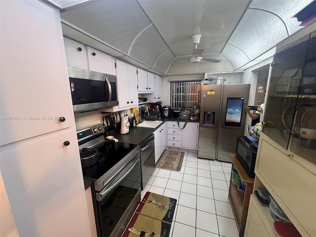 kitchen featuring ceiling fan, sink, stainless steel appliances, white cabinets, and light tile patterned floors