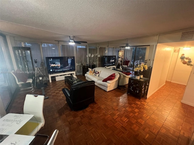 living room with ceiling fan and a textured ceiling