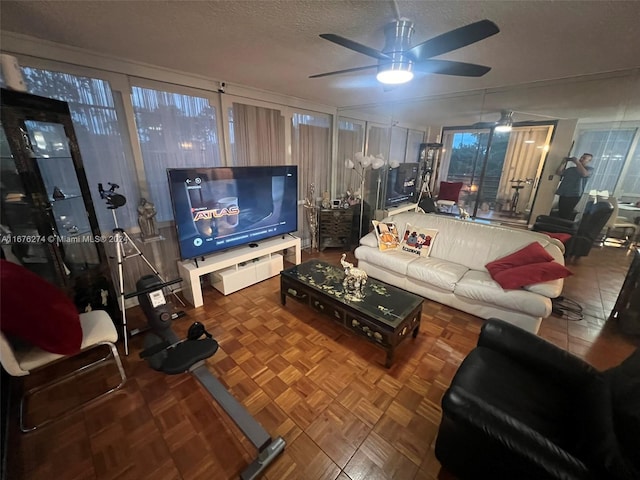 living room featuring ceiling fan, a textured ceiling, and parquet floors