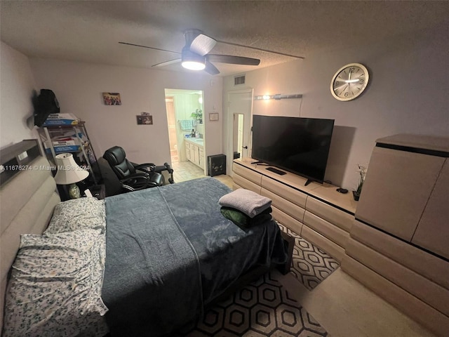 bedroom with ensuite bath, a textured ceiling, and ceiling fan