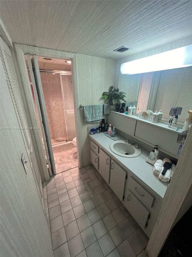 bathroom featuring tile patterned floors, an enclosed shower, vanity, and toilet