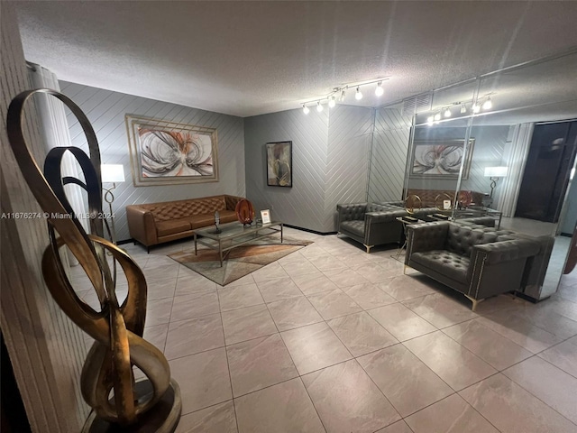 tiled living room with rail lighting and a textured ceiling