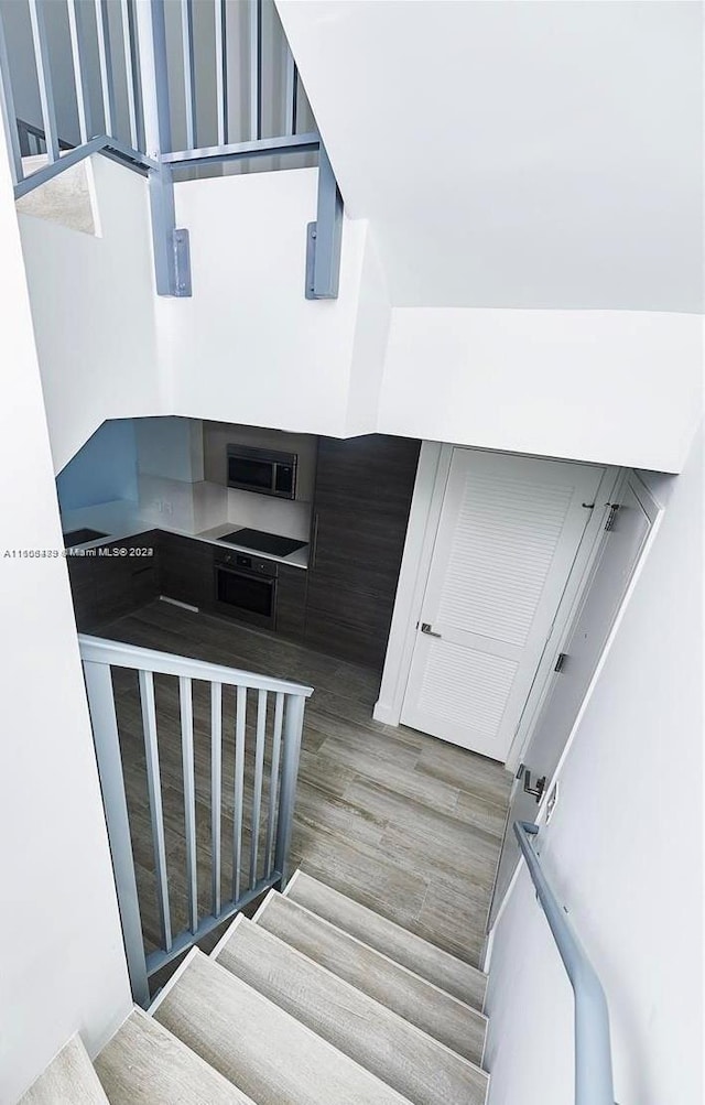 staircase with hardwood / wood-style flooring