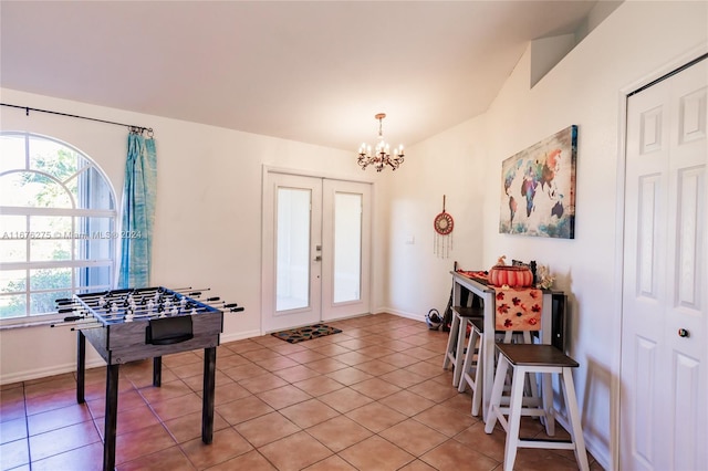 foyer with french doors, an inviting chandelier, and light tile patterned floors