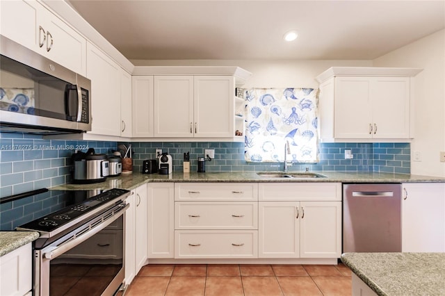 kitchen featuring backsplash, appliances with stainless steel finishes, sink, and white cabinetry