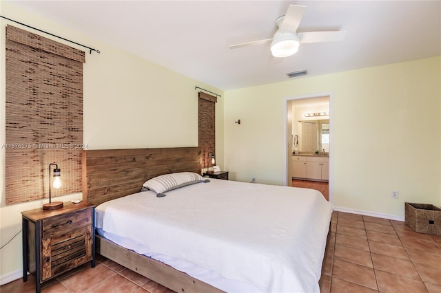 tiled bedroom with ceiling fan, wooden walls, and connected bathroom