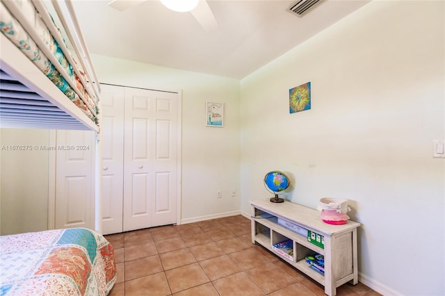 bedroom with ceiling fan, a closet, and light tile patterned floors