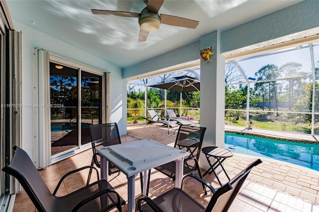 exterior space with ceiling fan, glass enclosure, and a patio