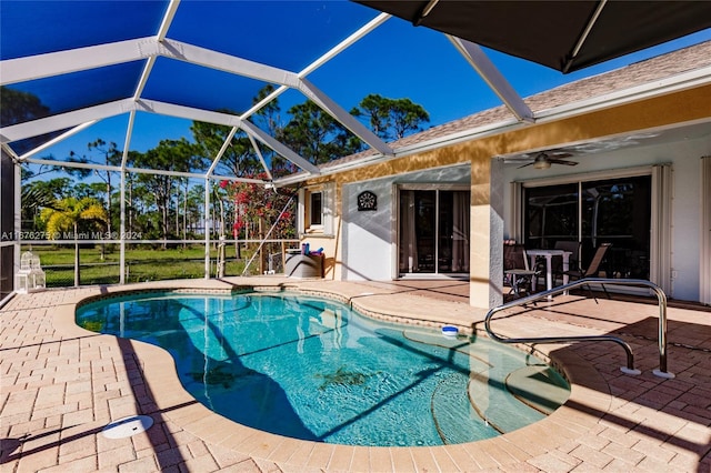 view of swimming pool with glass enclosure, ceiling fan, and a patio