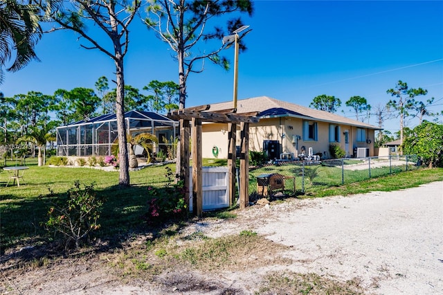 single story home with a lanai, cooling unit, and a front yard