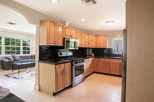 kitchen with arched walkways, visible vents, recessed lighting, stainless steel appliances, and backsplash