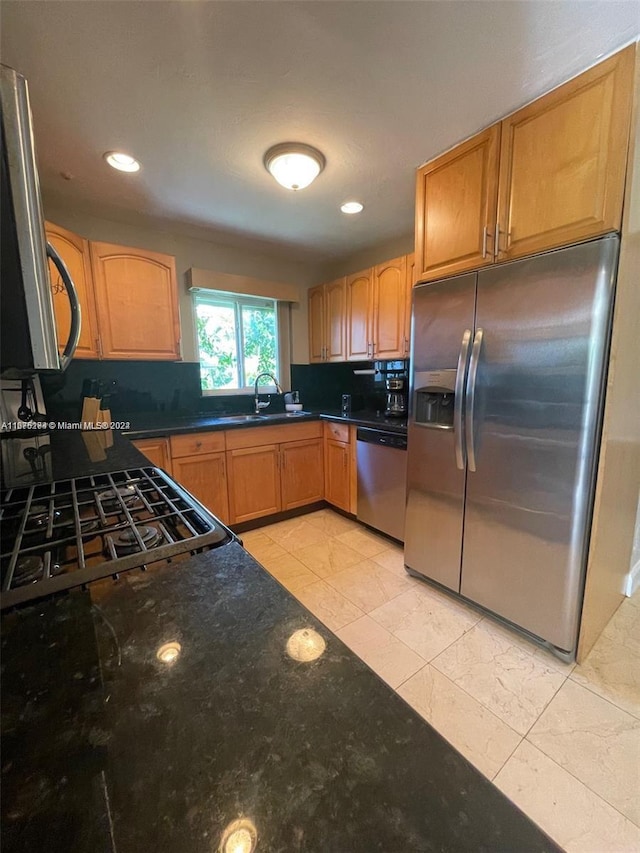 kitchen featuring dark stone counters, sink, stainless steel appliances, backsplash, and light tile patterned floors