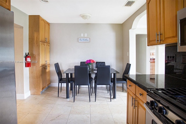 dining area with visible vents, baseboards, and arched walkways