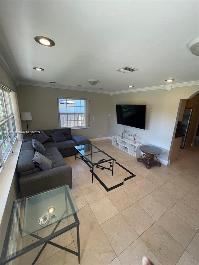 living room featuring arched walkways, light tile patterned floors, baseboards, and ornamental molding