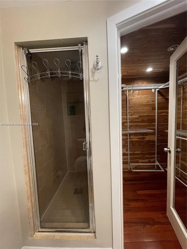 bathroom with hardwood / wood-style flooring and walk in shower