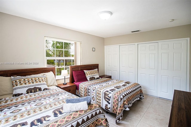 bedroom with light tile patterned floors, a closet, and visible vents