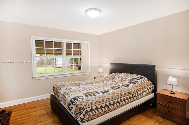 bedroom with baseboards and wood finished floors