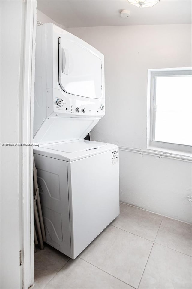 washroom featuring light tile patterned floors and stacked washing maching and dryer