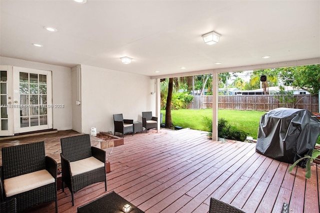 wooden terrace featuring french doors, grilling area, fence, and a lawn