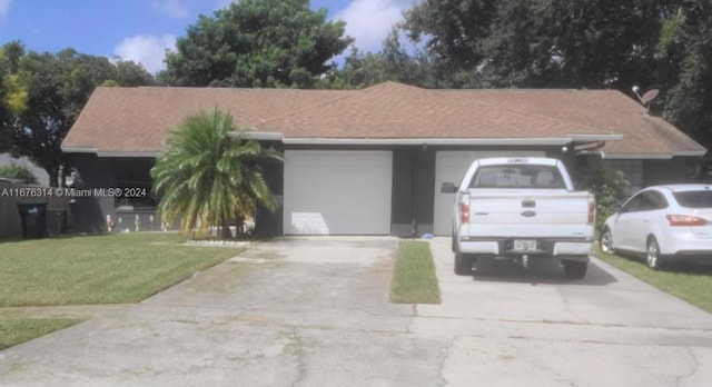 single story home featuring a garage and a front yard