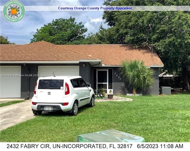 single story home featuring a garage, cooling unit, and a front lawn