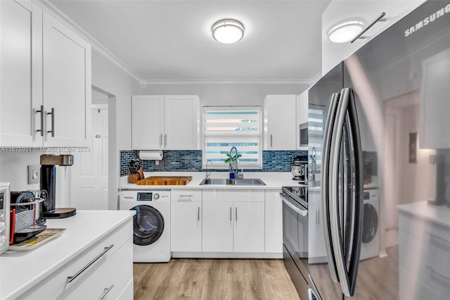 kitchen with white cabinets, stainless steel fridge, sink, washer / dryer, and black range with electric cooktop