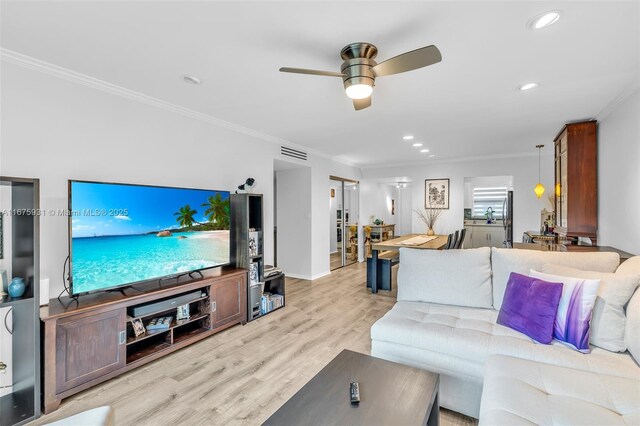 living room featuring ceiling fan, light wood-type flooring, and crown molding