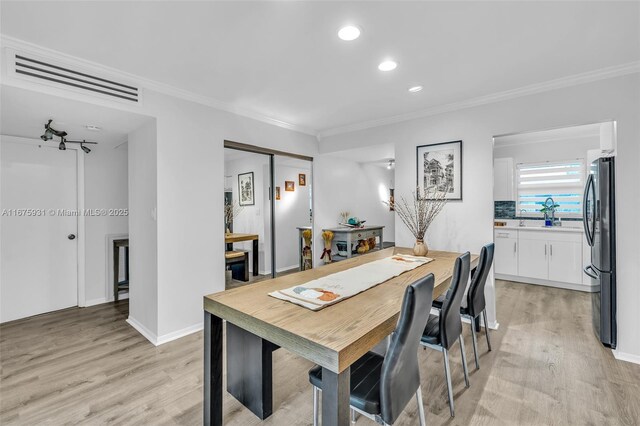 dining room featuring ornamental molding and light hardwood / wood-style flooring