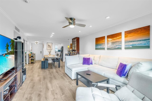 living room featuring ornamental molding, ceiling fan, and light hardwood / wood-style flooring