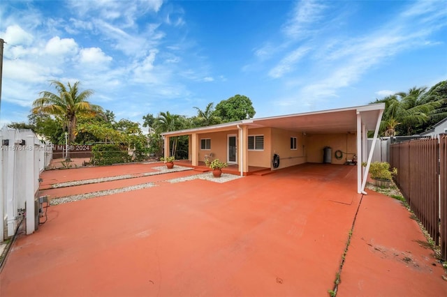 back of house featuring a carport and a patio area