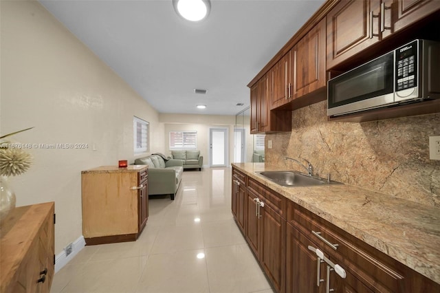 kitchen featuring backsplash, sink, and light tile patterned floors