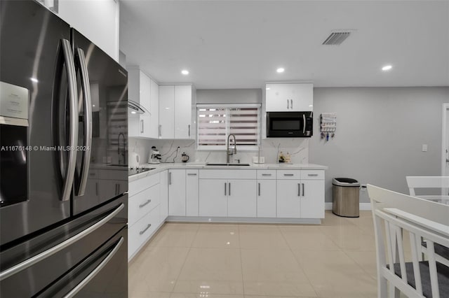 kitchen featuring white cabinets, stainless steel fridge, and sink