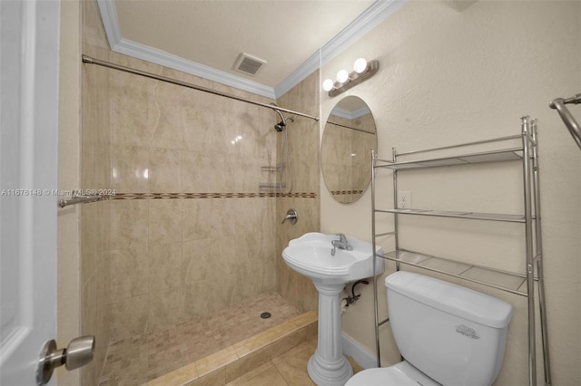 bathroom with a tile shower, crown molding, tile patterned flooring, toilet, and a textured ceiling