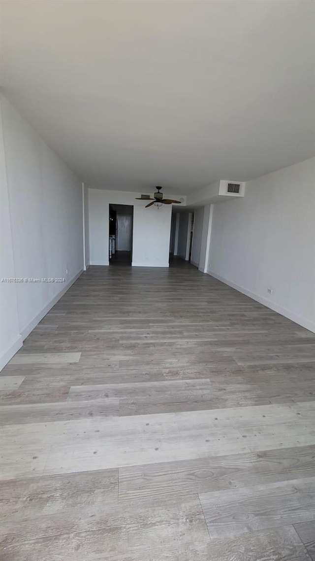 spare room featuring a ceiling fan, visible vents, baseboards, and light wood-style floors