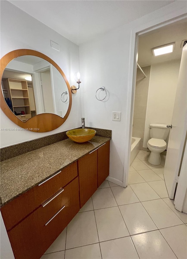full bath featuring toilet, tile patterned flooring,  shower combination, and vanity