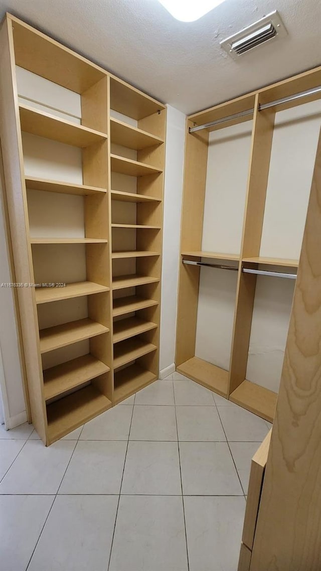 spacious closet with light tile patterned floors