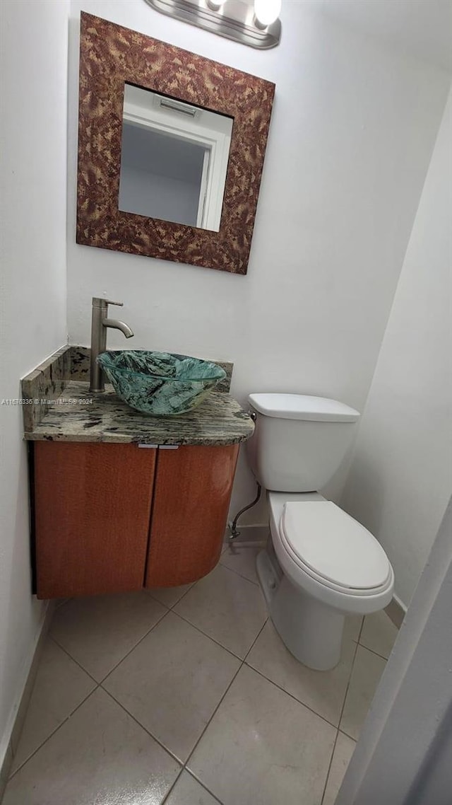 bathroom with tile patterned floors, toilet, vanity, and baseboards