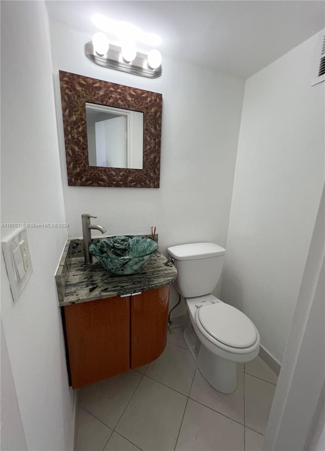 bathroom with toilet, tile patterned flooring, and vanity