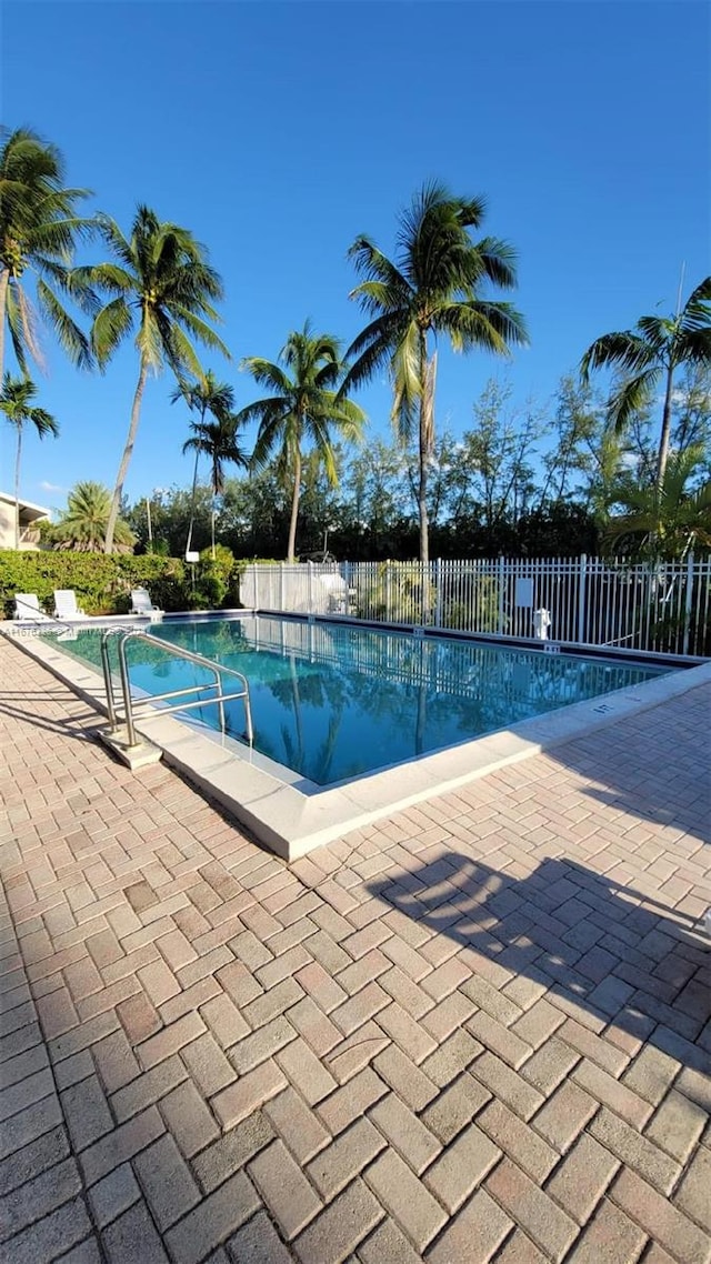 view of swimming pool featuring a patio, a fenced in pool, and fence