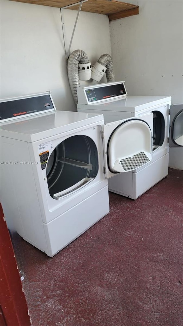 laundry room featuring washer and clothes dryer and dark carpet