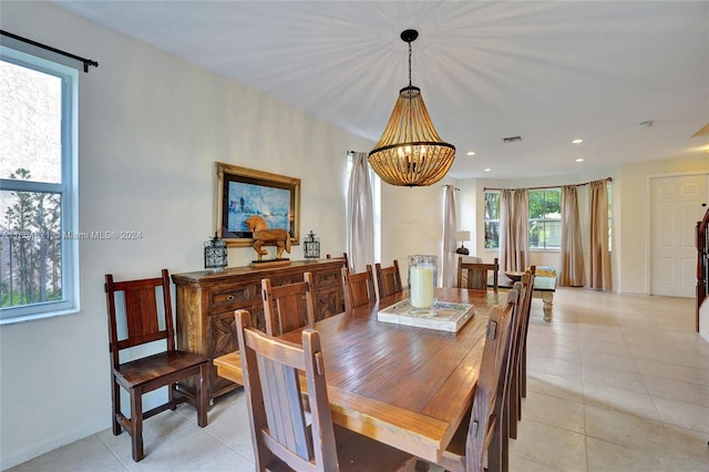 tiled dining area with a chandelier