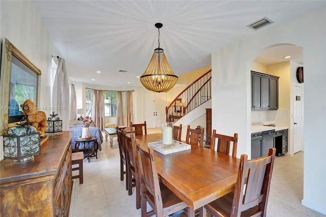 tiled dining room featuring wine cooler and an inviting chandelier