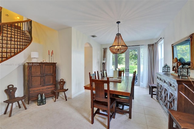 dining space with french doors, a notable chandelier, a healthy amount of sunlight, and light tile patterned floors