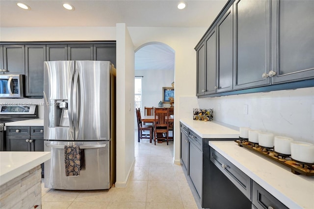 kitchen with light stone counters, appliances with stainless steel finishes, and light tile patterned floors