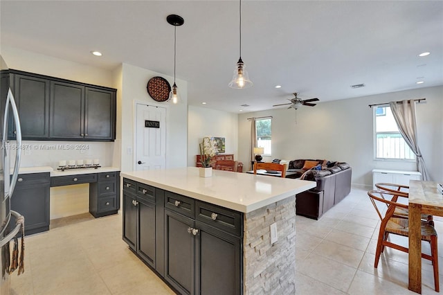 kitchen with a center island, a wealth of natural light, decorative light fixtures, and ceiling fan