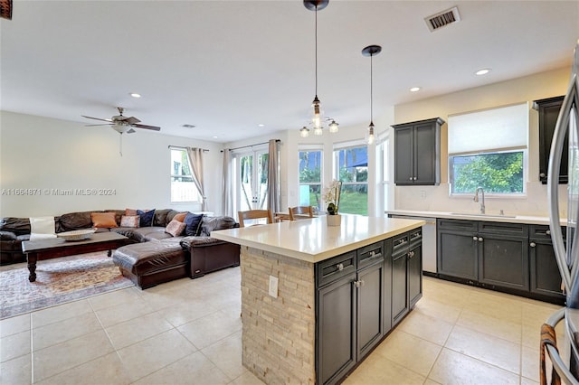 kitchen with a healthy amount of sunlight, decorative light fixtures, and a kitchen island