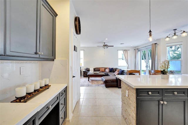 kitchen featuring light tile patterned flooring, hanging light fixtures, gray cabinetry, and plenty of natural light