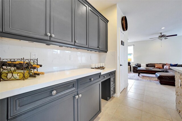 kitchen with gray cabinetry, ceiling fan, decorative backsplash, and light tile patterned floors