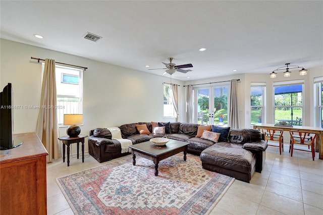 living room with a wealth of natural light, ceiling fan, and light tile patterned floors