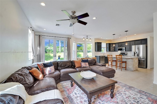 tiled living room with french doors and ceiling fan